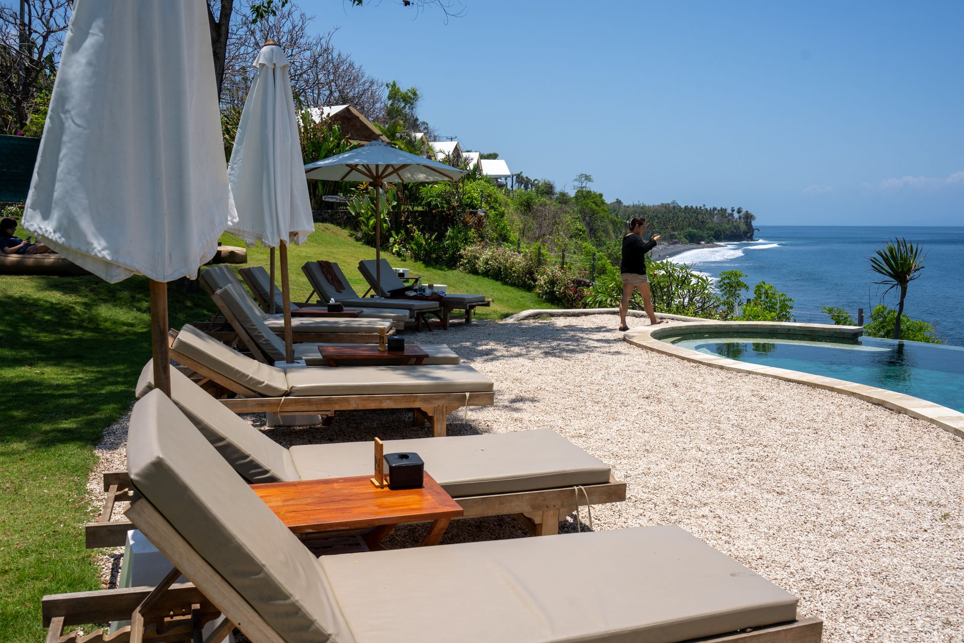 Couple relaxing at a luxury all-inclusive resort pool overlooking a turquoise Caribbean beach