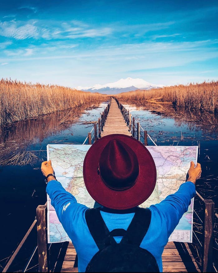 An adventurer plans a journey with a map; every trip booked through our ministry travel giving program gives back.